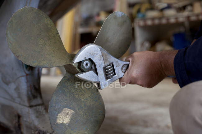Man tightening boat propeller in workshop — Stock Photo