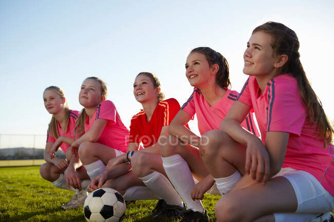 Équipe de football souriant ensemble sur le terrain — Photo de stock