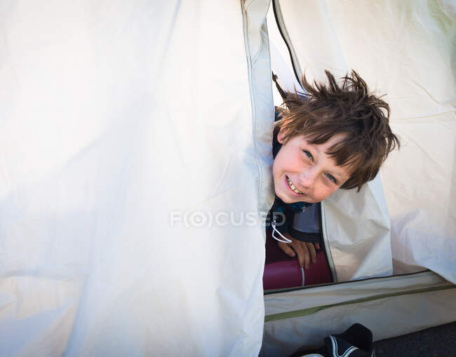 Rapaz a olhar para fora da tenda — Fotografia de Stock