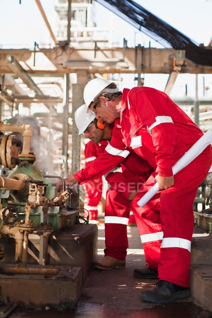 Travailleurs examinant l'équipement sur place — Photo de stock