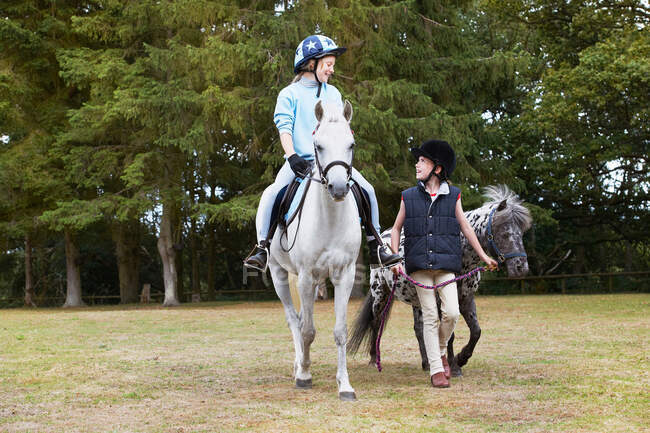 Two girls out riding ponies — Stock Photo