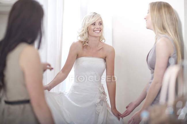 Junge Frau probiert mit Freunden Hochzeitskleid an — Stockfoto