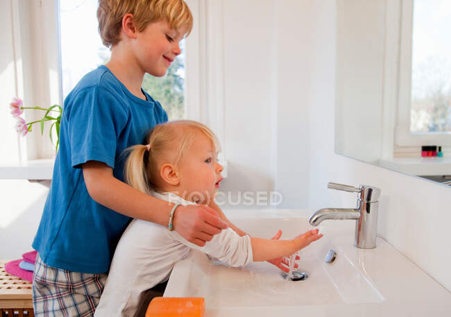 Bruder und Schwester waschen sich die Hände — Stockfoto