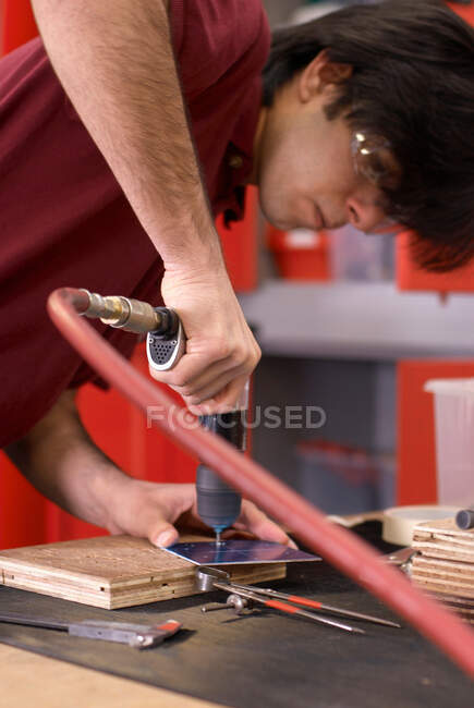 Trabajador usando taladro en fábrica - foto de stock