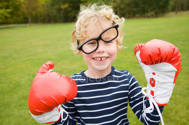 Menino brincando com luvas de boxe ao ar livre — Fotografia de Stock