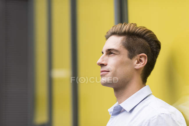 Porträt eines jungen Geschäftsmannes, der sich außerhalb des Büros lehnt, London, Großbritannien — Stockfoto