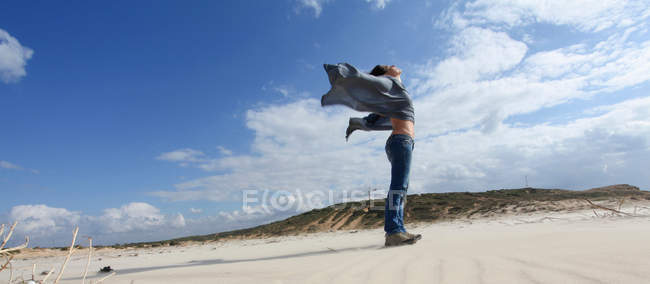Жінка стоїть на вітряному пляжі — стокове фото
