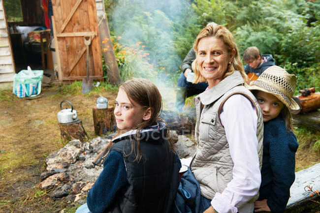 Grandparents and children by camp fire — Stock Photo