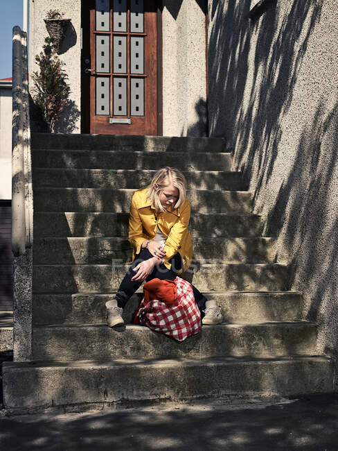 Sad girl sitting on steps — Stock Photo