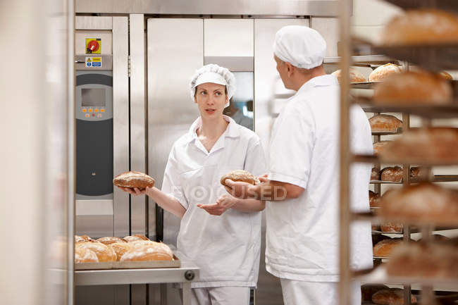 Chefs talking at oven in kitchen — Stock Photo