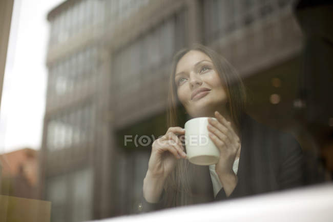 Geschäftsfrau blickt durch Café-Fenster, Freiburg, Deutschland — Stockfoto