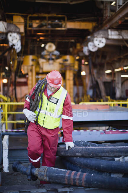 Arbeiter trägt Seil auf Ölplattform — Stockfoto