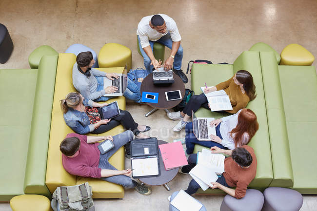 Visão geral de sete estudantes do sexo masculino e feminino brainstorming no ensino superior espaço de estudo universitário — Fotografia de Stock