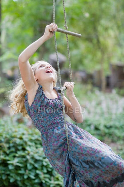 Girl climbing rope ladder — Stock Photo