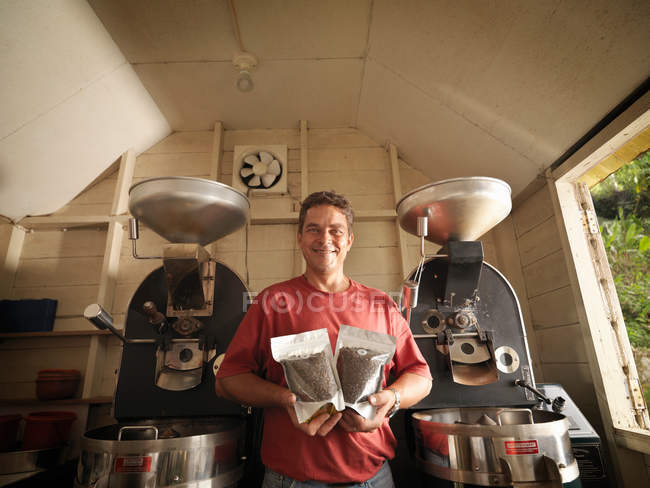 Trabajador de café con granos de café envasados - foto de stock