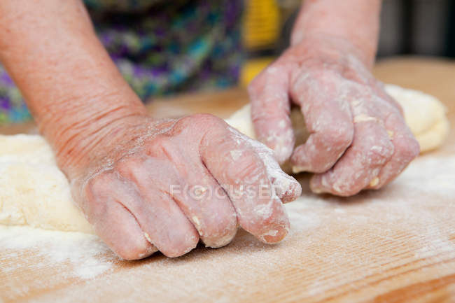Крупный план женщины месить тесто, обрезанный выстрел — стоковое фото