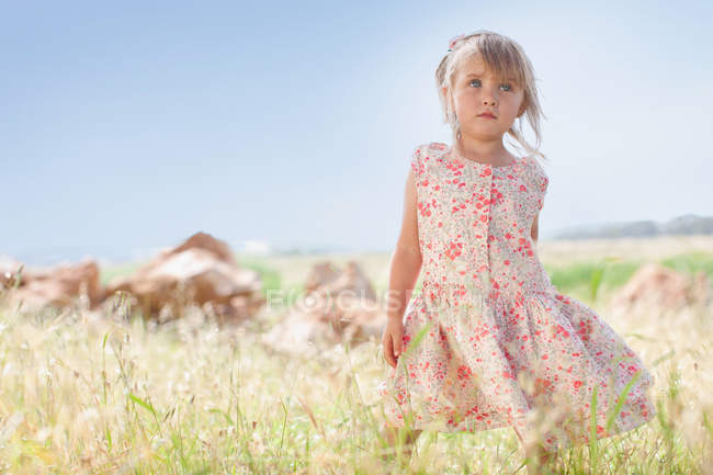 Девушка стоит в высокой траве на открытом воздухе — стоковое фото