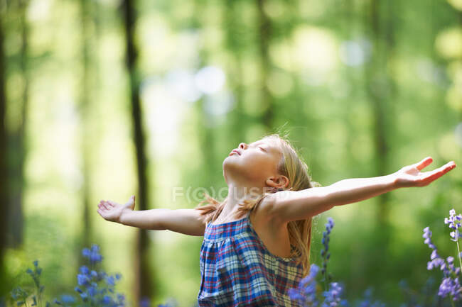 Girl standing in field of flowers — Stock Photo