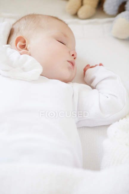 Baby girl sleeping in crib — Stock Photo