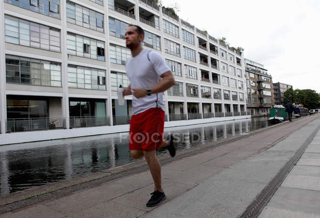 Чоловік біжить по міській вулиці — стокове фото