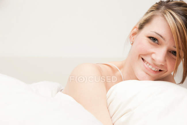 Retrato de mujer joven en la cama - foto de stock