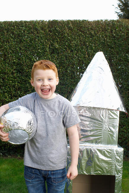 Junge spielt mit Raumschiff aus Pappe — Stockfoto