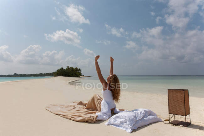 Femme se réveillant au lit sur la plage — Photo de stock