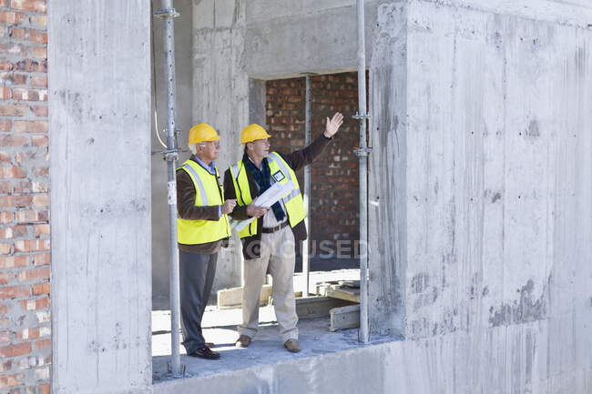 Businessman and worker talking on site — Stock Photo