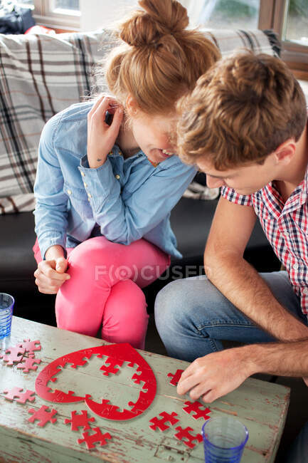 Casal fazendo jigsaw em forma de coração — Fotografia de Stock
