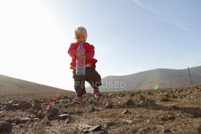 Toddler carrying bottle of water — Stock Photo