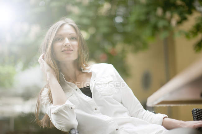 Hermosa mujer relajándose en la cafetería de la acera, Friburgo, Alemania - foto de stock