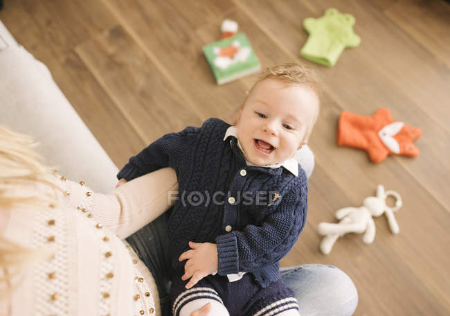 Mother holding baby on lap at home — Stock Photo