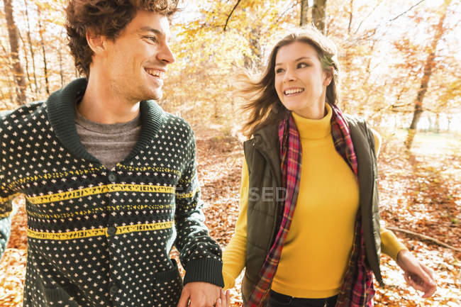 Пара тримає руки, посміхаючись один одному — стокове фото