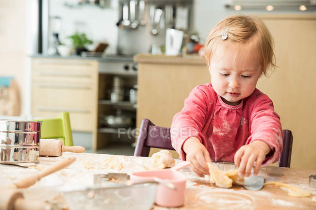 Bebê menina assar na cozinha — Fotografia de Stock