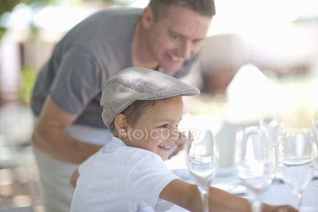 Padre e hijo poniendo mesa - foto de stock