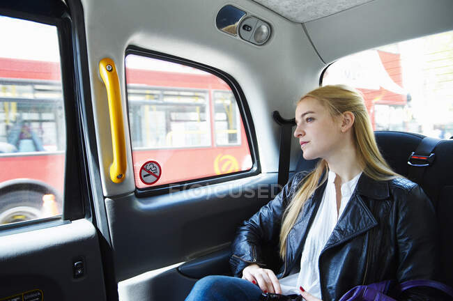 Mulher sentada no táxi e olhando na janela — Fotografia de Stock