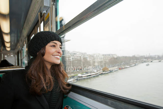 Smiling woman riding train over water — Stock Photo