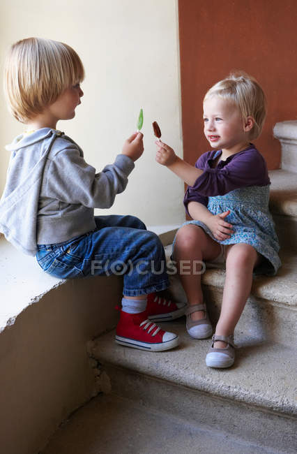 Bambini che confrontano bastoncini di ghiacciolo — Foto stock