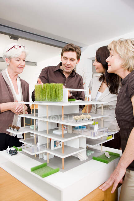 Equipe discutindo modelo de arquitetura — Fotografia de Stock