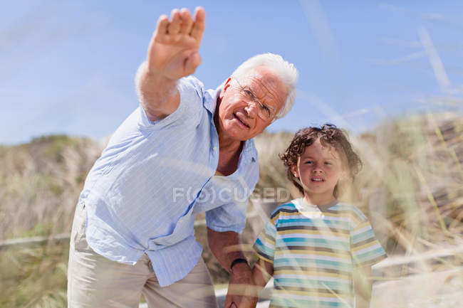Older man and grandson standing outdoors — Stock Photo