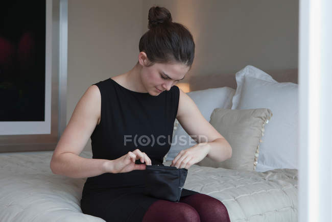 Femme regardant dans un sac de maquillage — Photo de stock