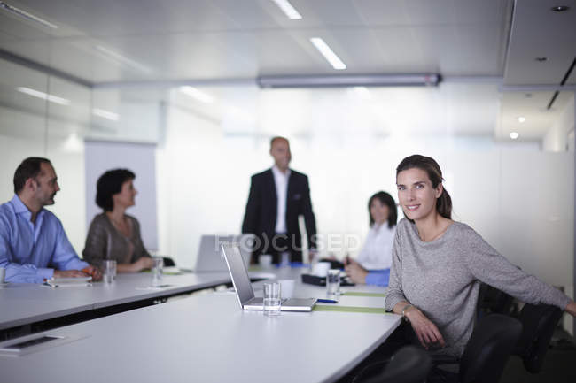 Porträt einer Geschäftsfrau mit Kollegen am Vorstandstisch — Stockfoto