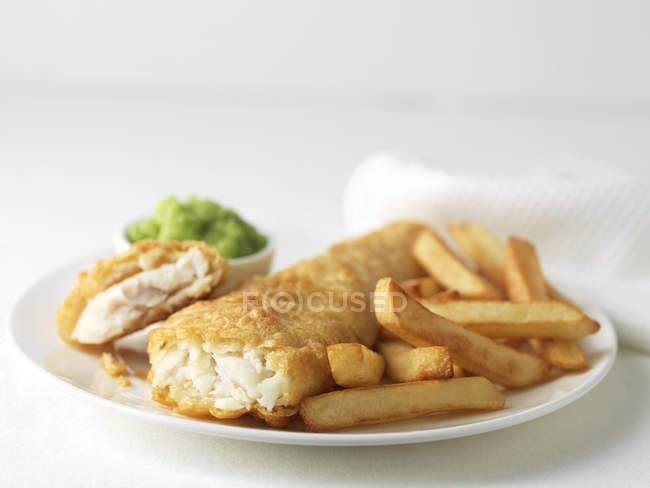 Placa de bacalao maltratado y patatas fritas - foto de stock