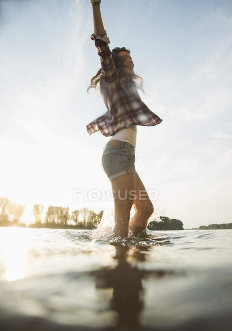 Young woman paddling in lake — Stock Photo