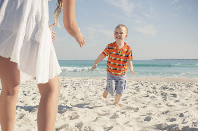 Madre giocare con giovane figlio su spiaggia — Foto stock