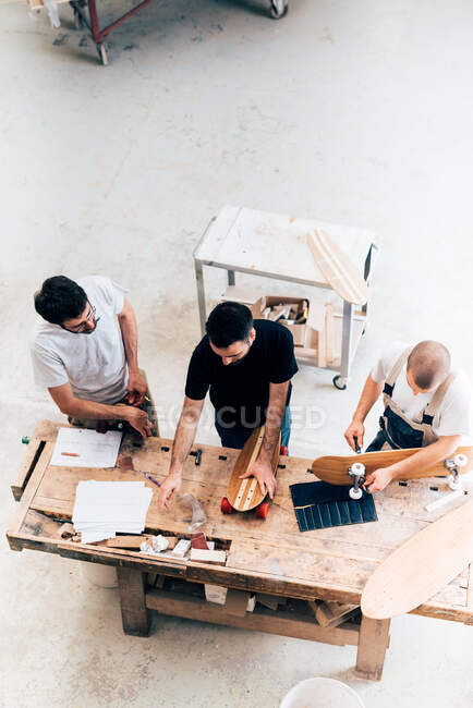 Мужчины работают на скейтбордах в мастерской — стоковое фото