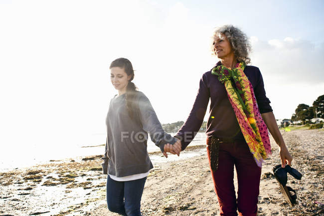 Madre e hija disfrutando de la playa soleada - foto de stock