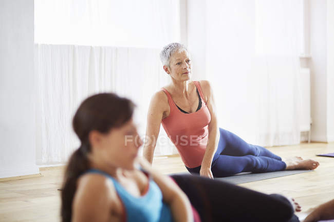Dos mujeres acostadas de lado en clase de pilates - foto de stock