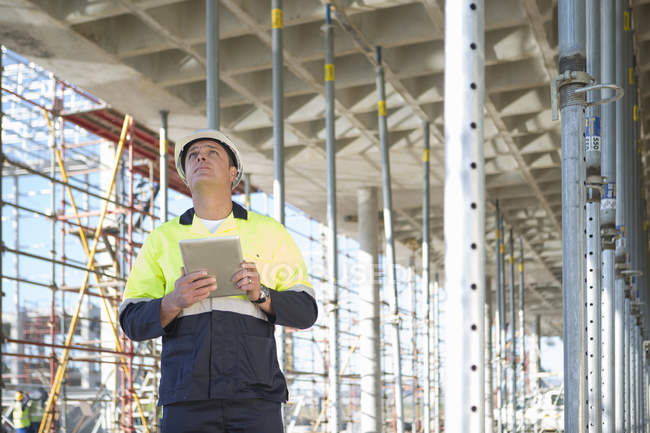 Site manager using digital tablet on construction site — Stock Photo