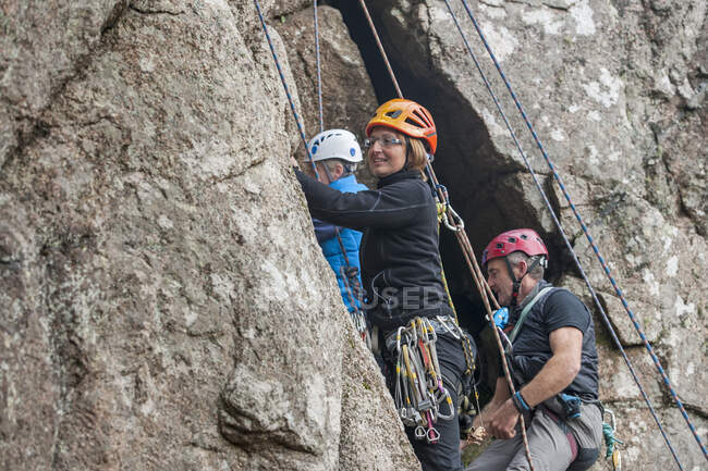 Three rock climbers on cliff — Stock Photo